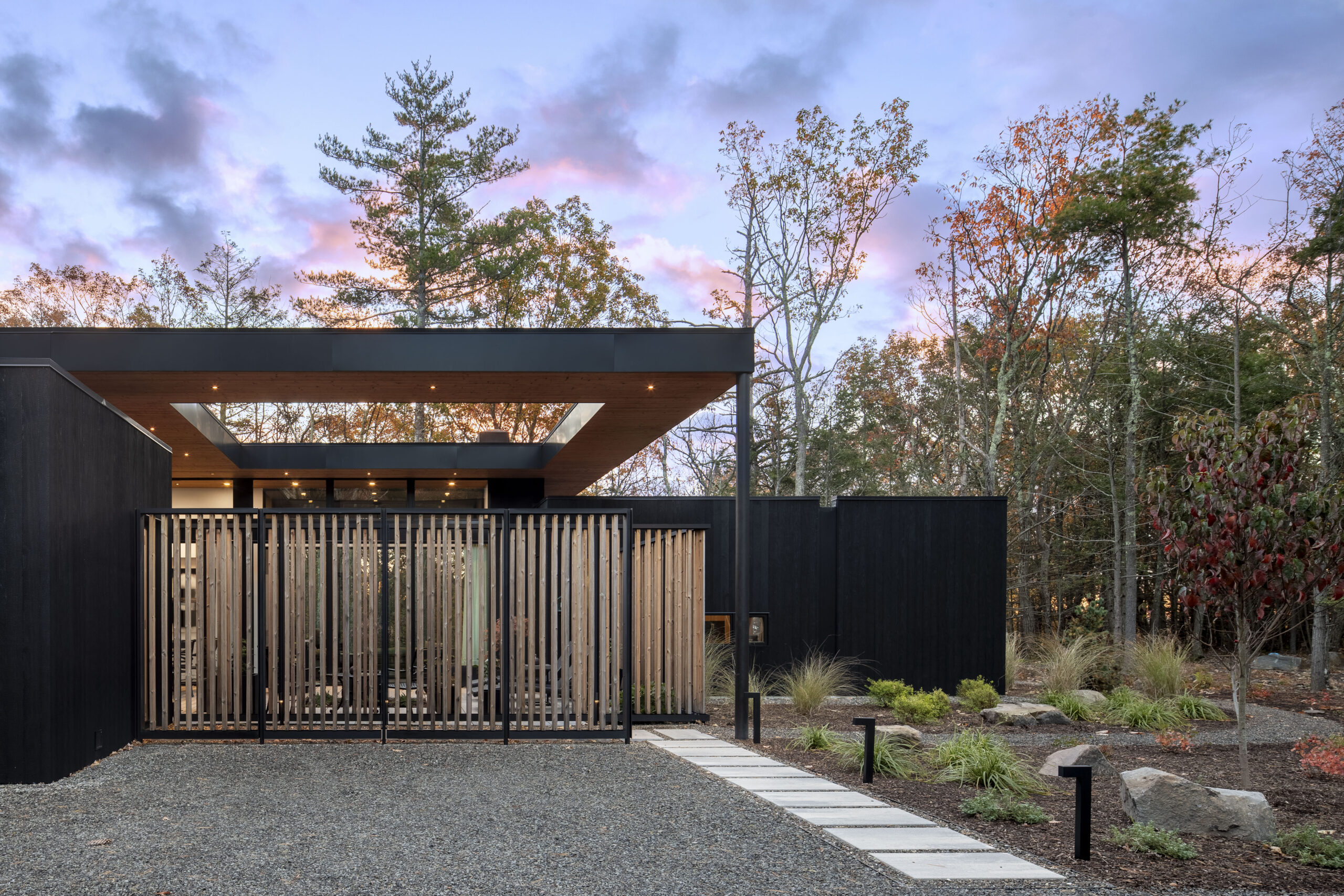 A view of Fermata from the guest parking area shows the home's screened courtyard and large overhanging roof.