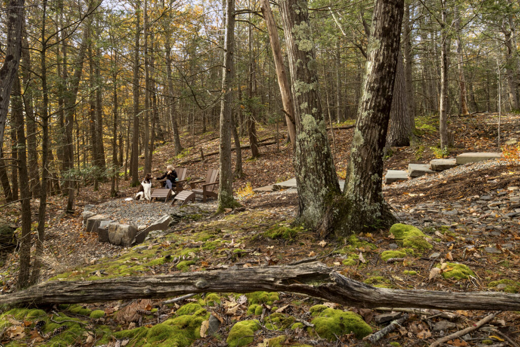 A small gravel patio sits just below the home and is a place for our client and her dog to connect.