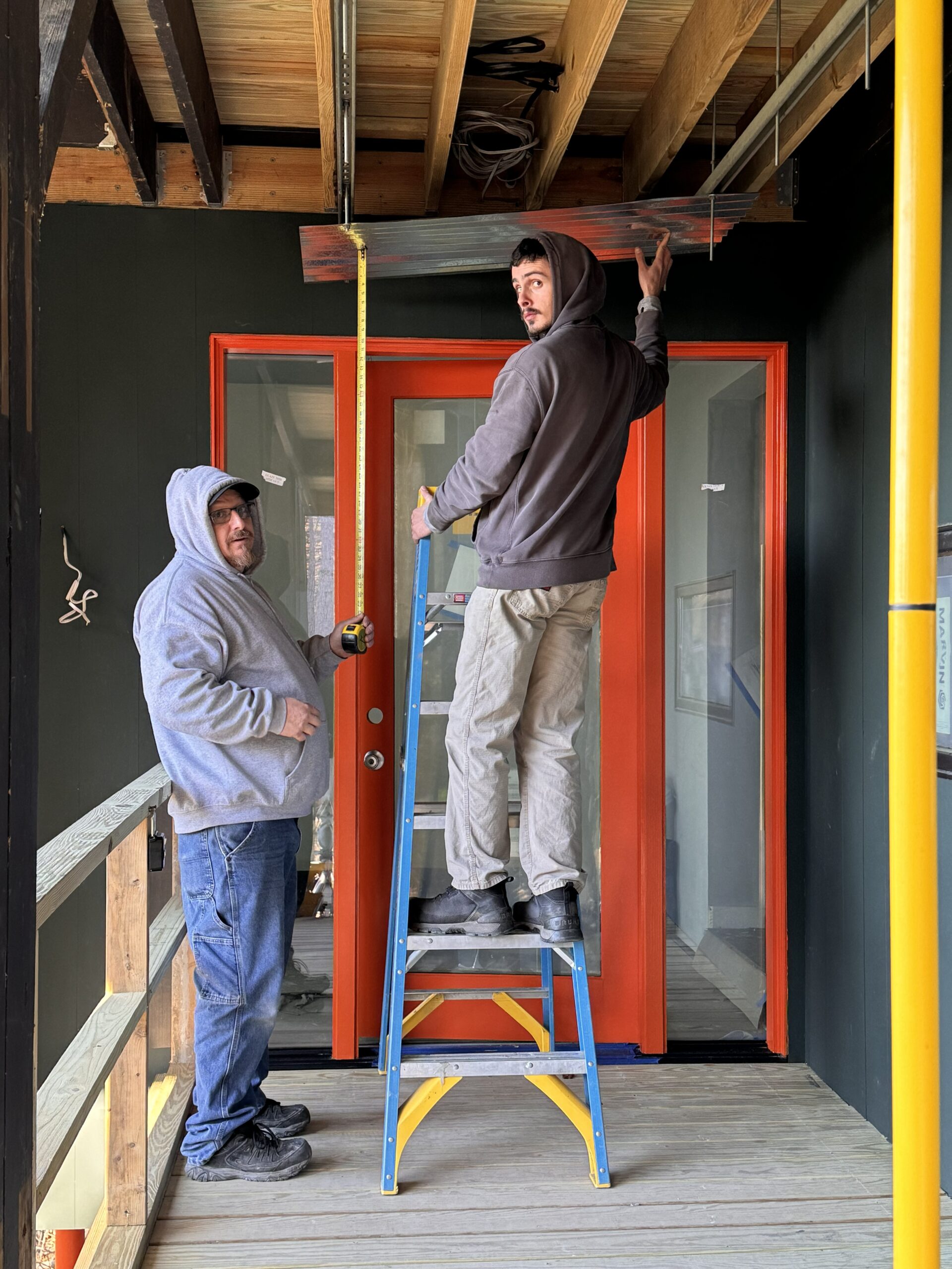 New entry and corrugated metal roof being installed at Woodland Pop House