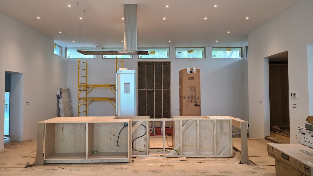 Interior view of Artists' Ranch during finishing phase, showing the kitchen island and hood coming along beautifully.