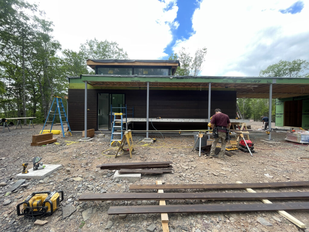Exterior view of Quattro under construction in Saugerties, showing completed siding installation and the home's modern profile taking shape.