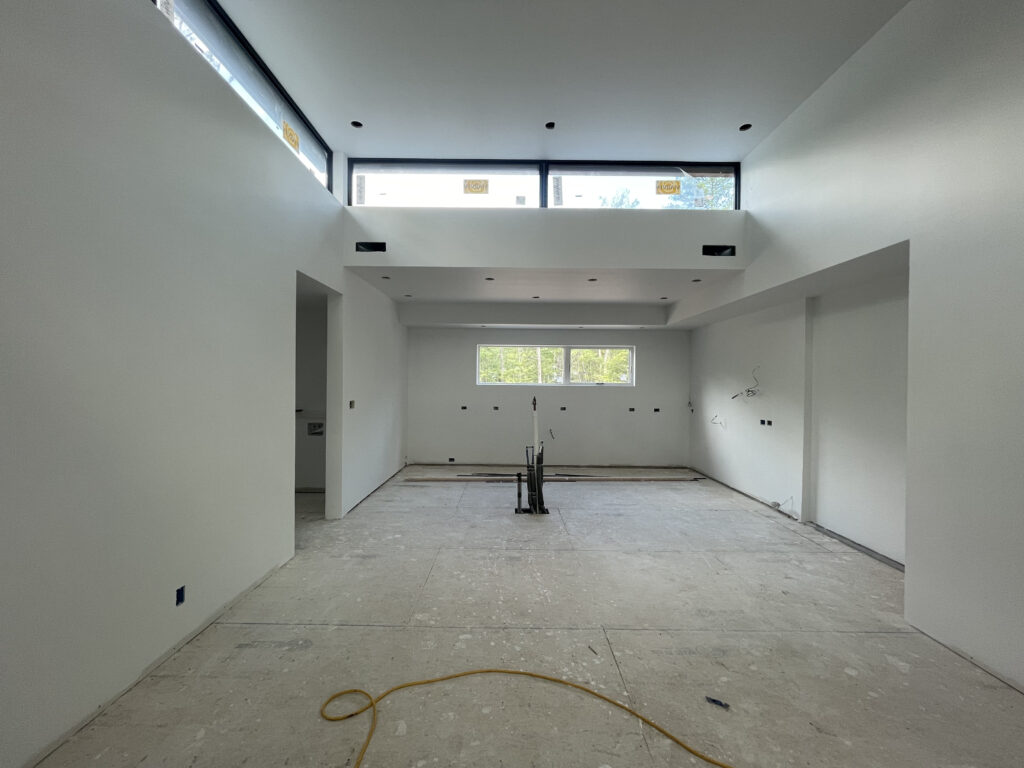 Wide interior shot of Quattro during finishing phase, showing the scale of the open-concept space with clerestory framing and natural light.