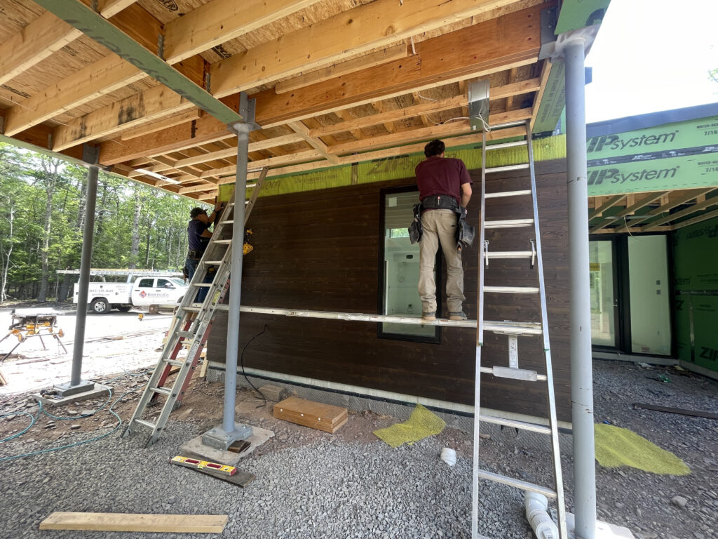 Exterior progress at Quattro with siding installation underway, showing the home's contemporary horizontal profile against the Saugerties landscape.