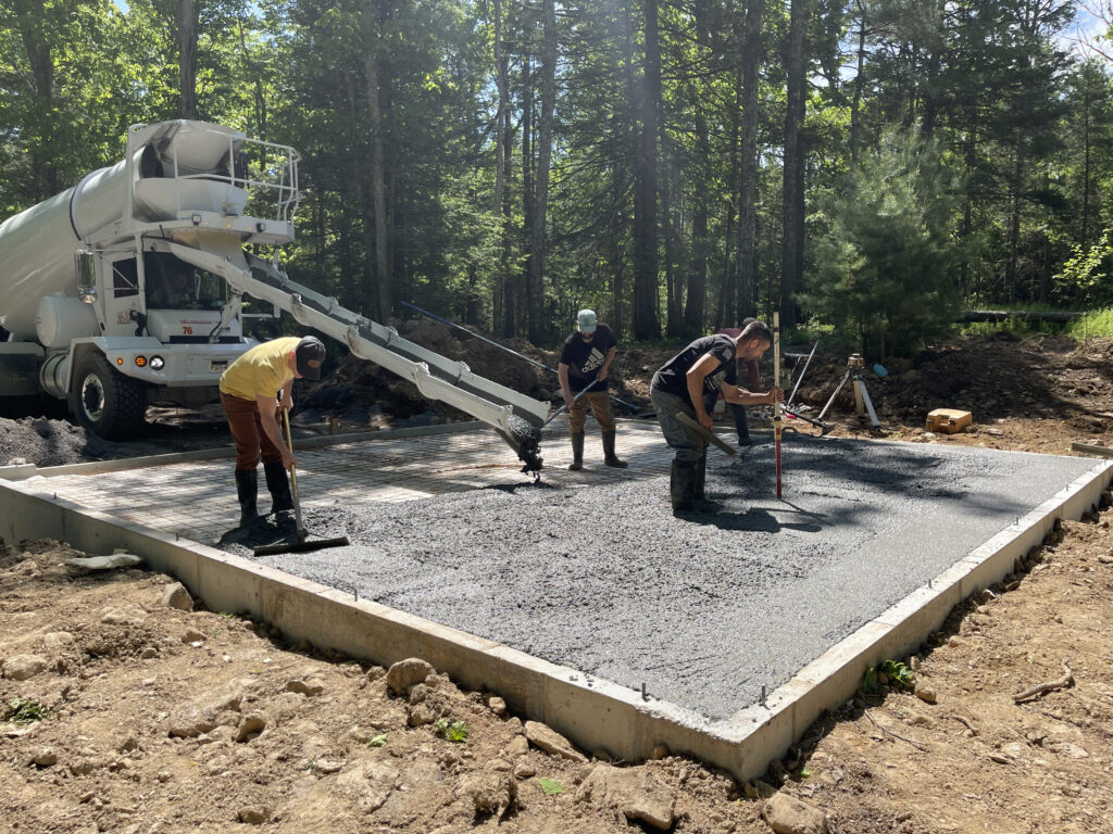 Concrete slab pour in progress at the Gallery at Cluster One, with formwork and reinforcement visible across the foundation.