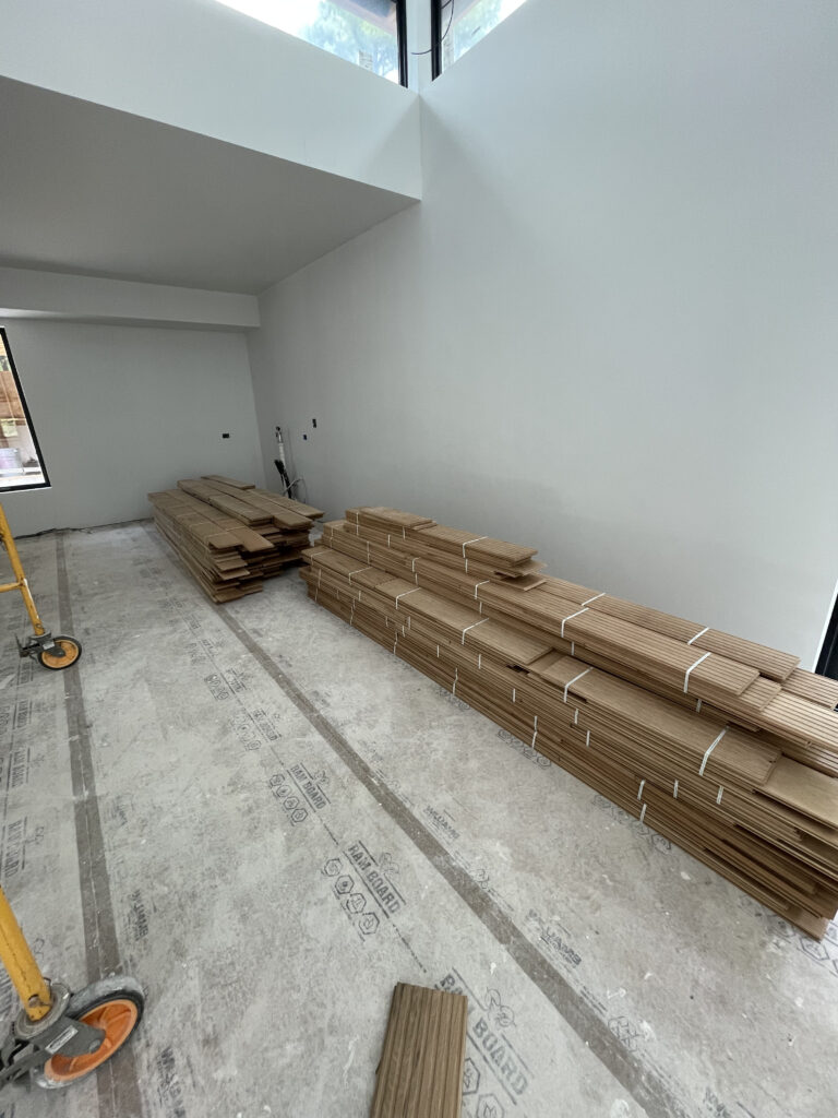 Quattro construction site showing interior finishing phase with completed drywall and painting progress throughout the open-plan living areas.