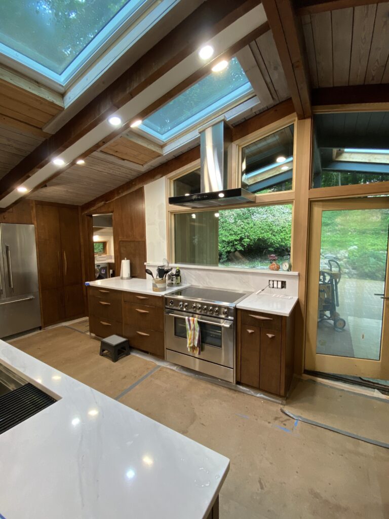 Completed kitchen cabinet installation at MCM Reno, with crisp cabinetry in place and countertop and appliance installation underway.