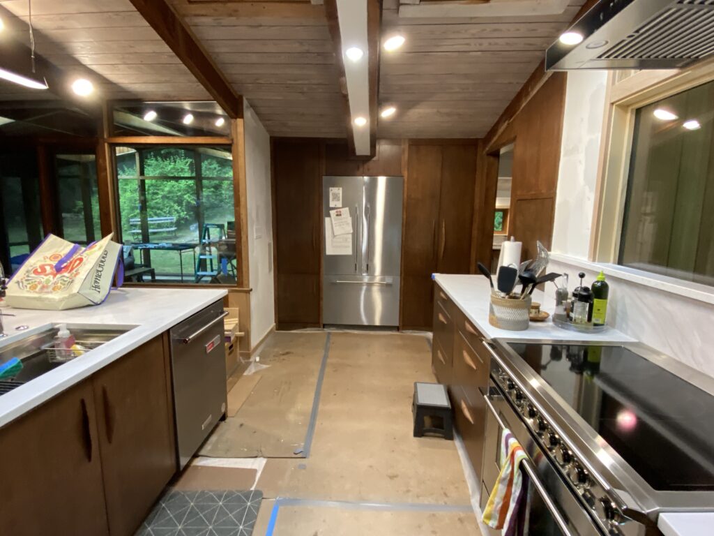 Wide kitchen view at MCM Reno with cabinets, appliances, and countertops installed, capturing the transformation of this renovated home.