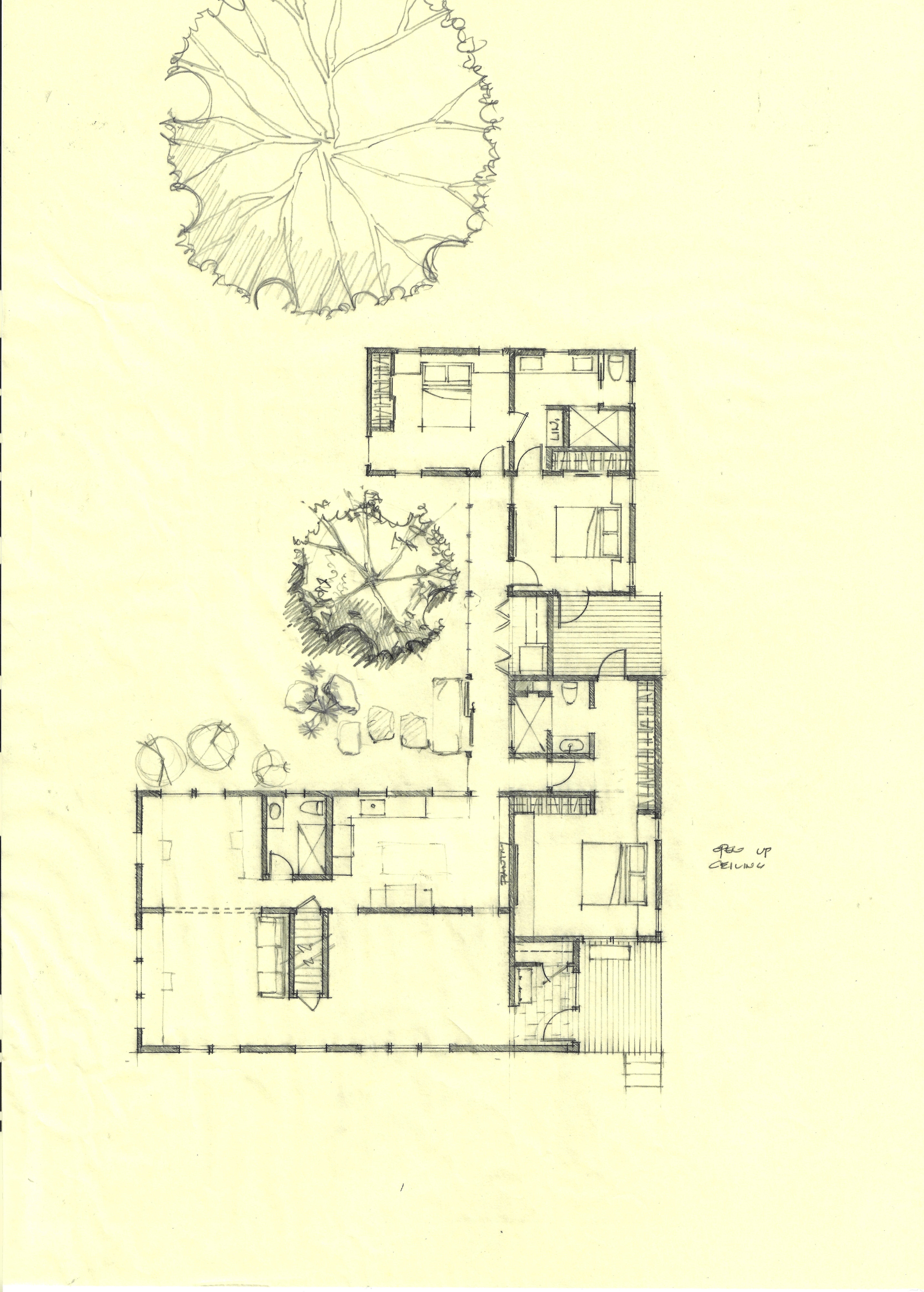 Hand-drawn pencil floor plan on yellow trace paper showing a ground-level layout with bedrooms, bathrooms, closets, and a deck