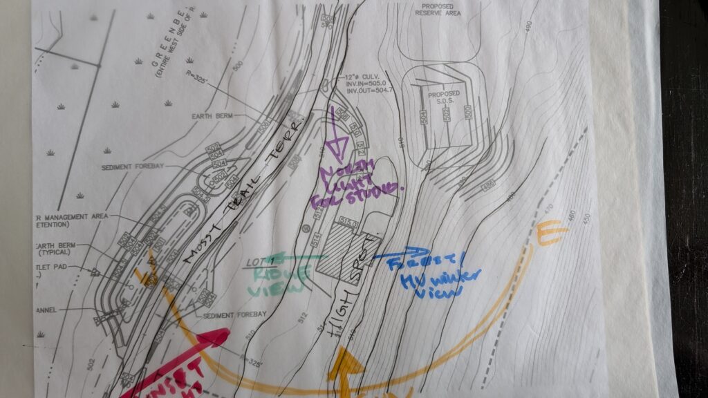 Topographic site survey drawing with colored hand annotations marking north light, ridge view, and front winter view around a house footprint